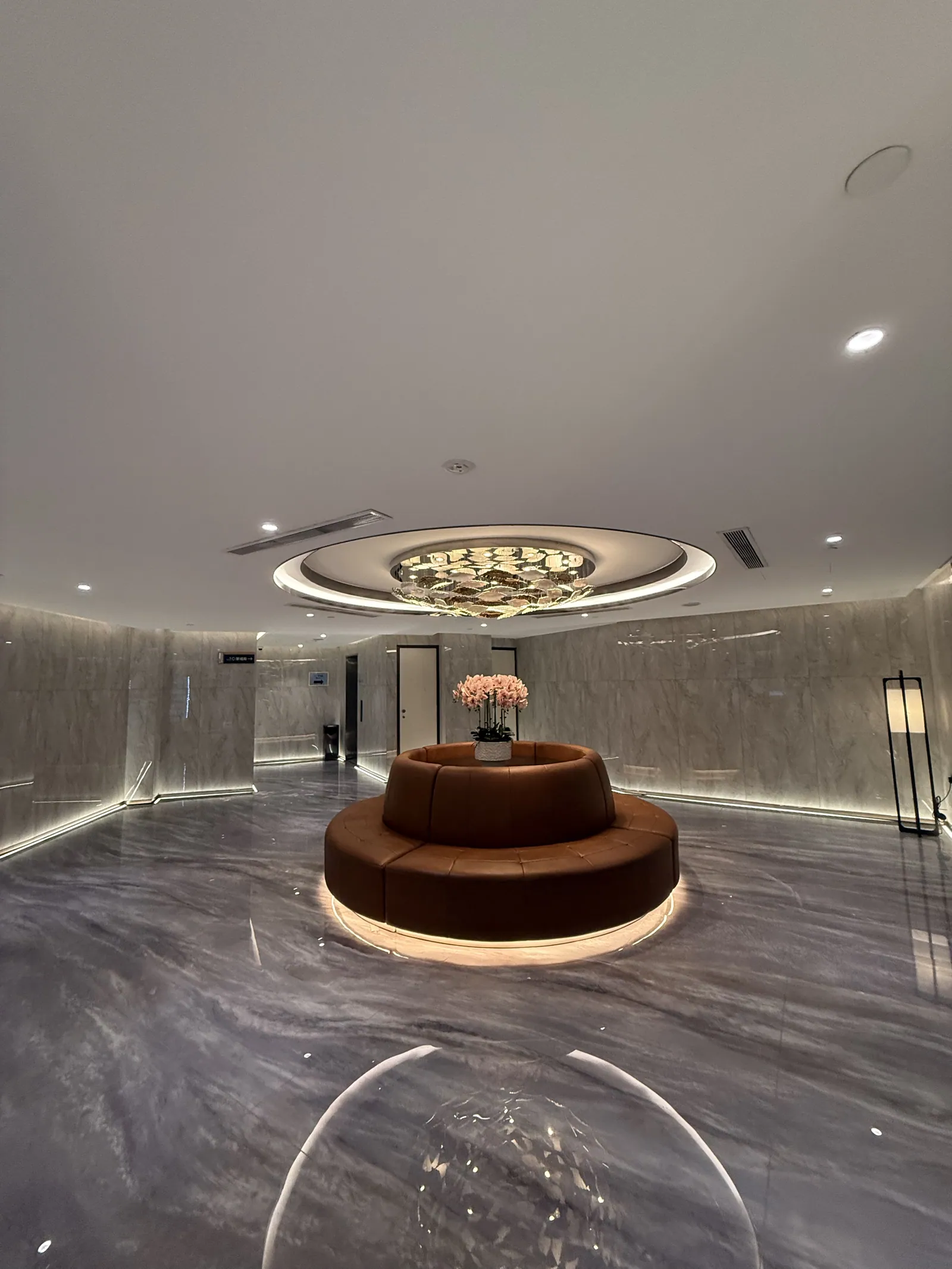 The reception lobby with circular seating beneath a gold ceiling feature