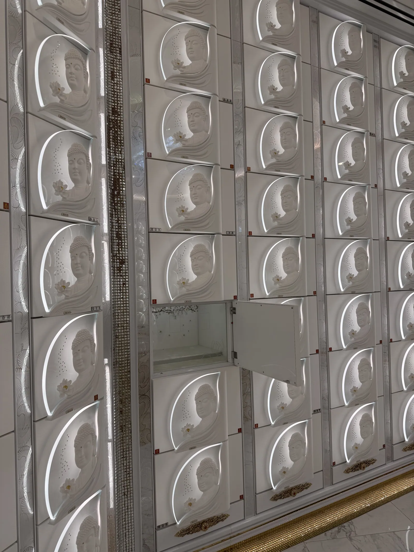 A tall wall of white niches behind glass