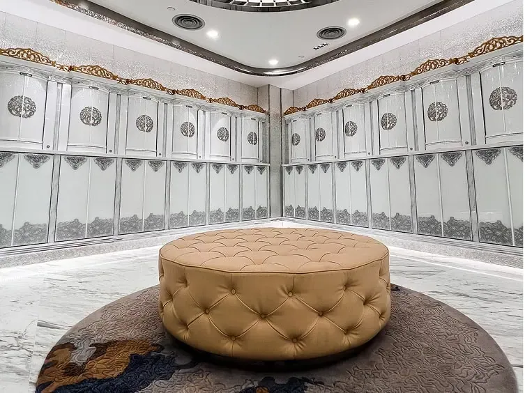 A family suite room lined with niches on every wall, with a round upholstered seat at its centre