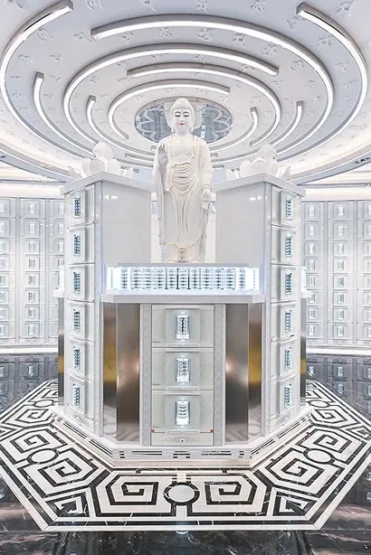 A tiered memorial tower topped by a standing figure, on a patterned floor