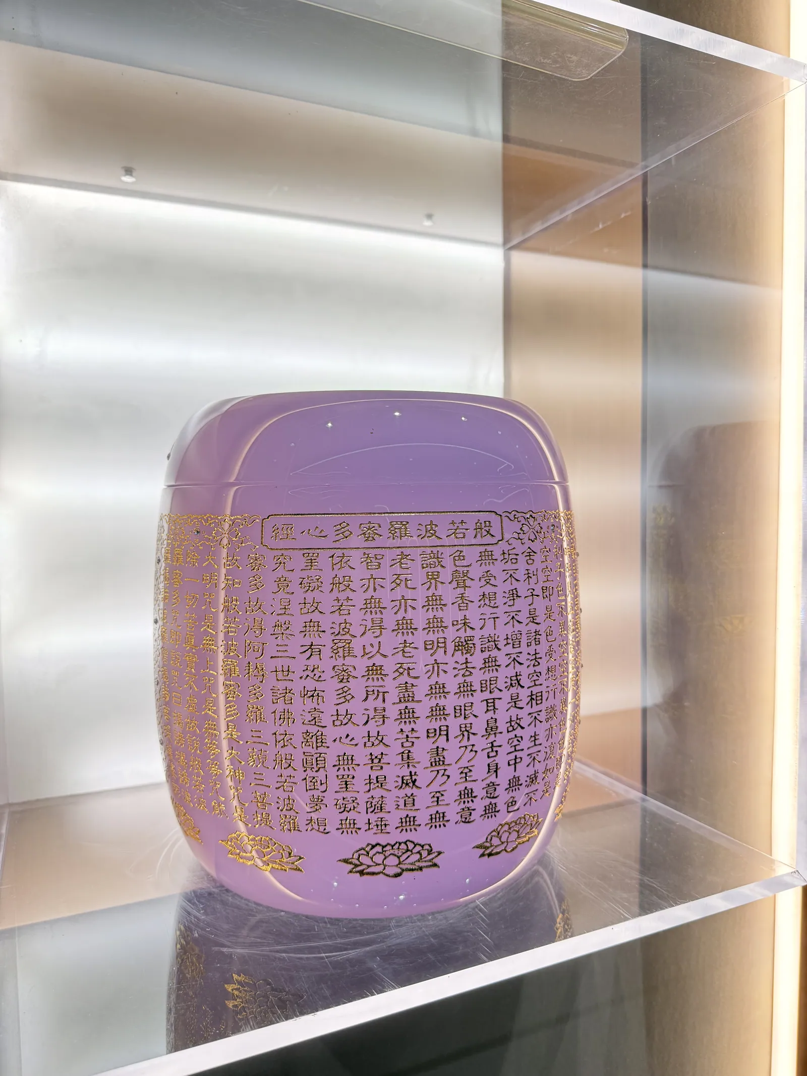 A lilac urn covered in gilded sutra text